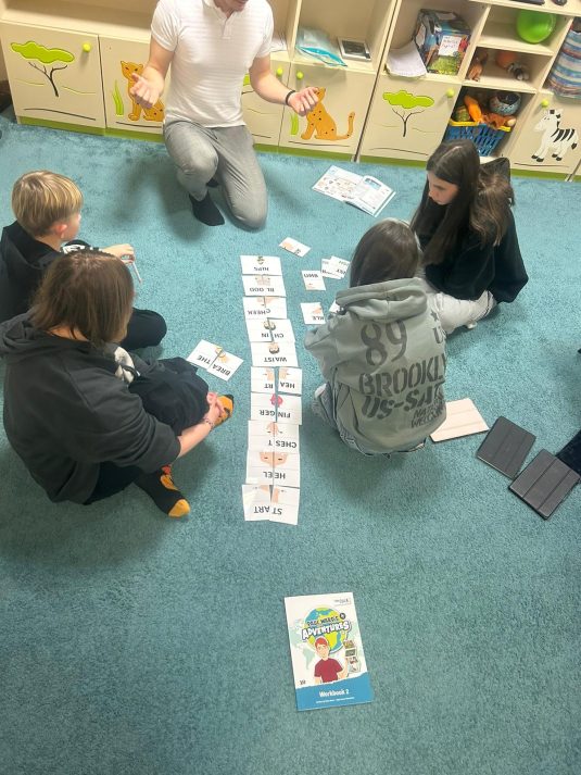 Nauka po za schematami czyli współpraca w obrębie dywanowej przestrzeni. Wykorzystanie ruchu, pomocy edukacyjnych i zmysłów pozwala na lepsze zapamiętywanie językowych treści.